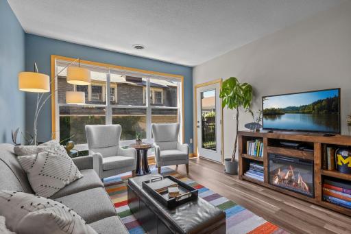Living room with gas fireplace and door out to the private balcony