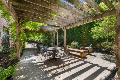 Lush outdoor garden with a shaded pergola and seating for residents