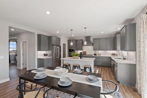 Informal dining and a island with seating provides plenty of space for family dinners or entertaining a crowd. Photo of model home, colors and finishes may vary.