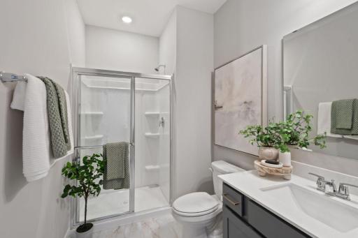 Here you see the main level ensuite bathroom. Photo of model home, colors and finishes may vary.