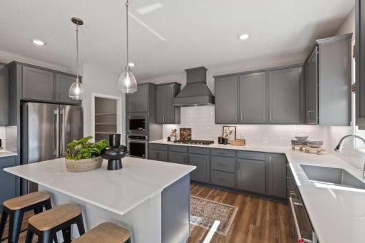 Photo for 1918 Shady View Court, Shakopee, MN 55379 - listing #7108837 Welcome to your gourmet kitchen, complete with gas cooktop, wood hood vent, tile backsplash, and center island. This home will have white cabinets. Photo of model, colors and finishes may vary.