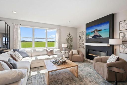 The living room is the perfect place for everyone to gather. The electric fireplace provides a cozy ambiance in this space. Photo of model home, colors and finishes may vary.