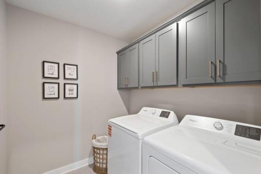 The laundry room has an abundance of space and convenient cabinets for storage of your laundry essentials. Photo of model home, color and finishes will vary.