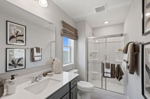 The 3/4 bathroom in the junior suite offers quartz counters and ample cabinet space. Photo of model home, colors and finishes may vary.