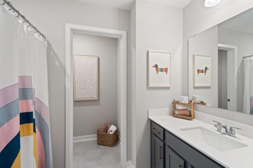 The full bathroom on the upper level includes a private water closet. Photo of model home, colors and finishes may vary.