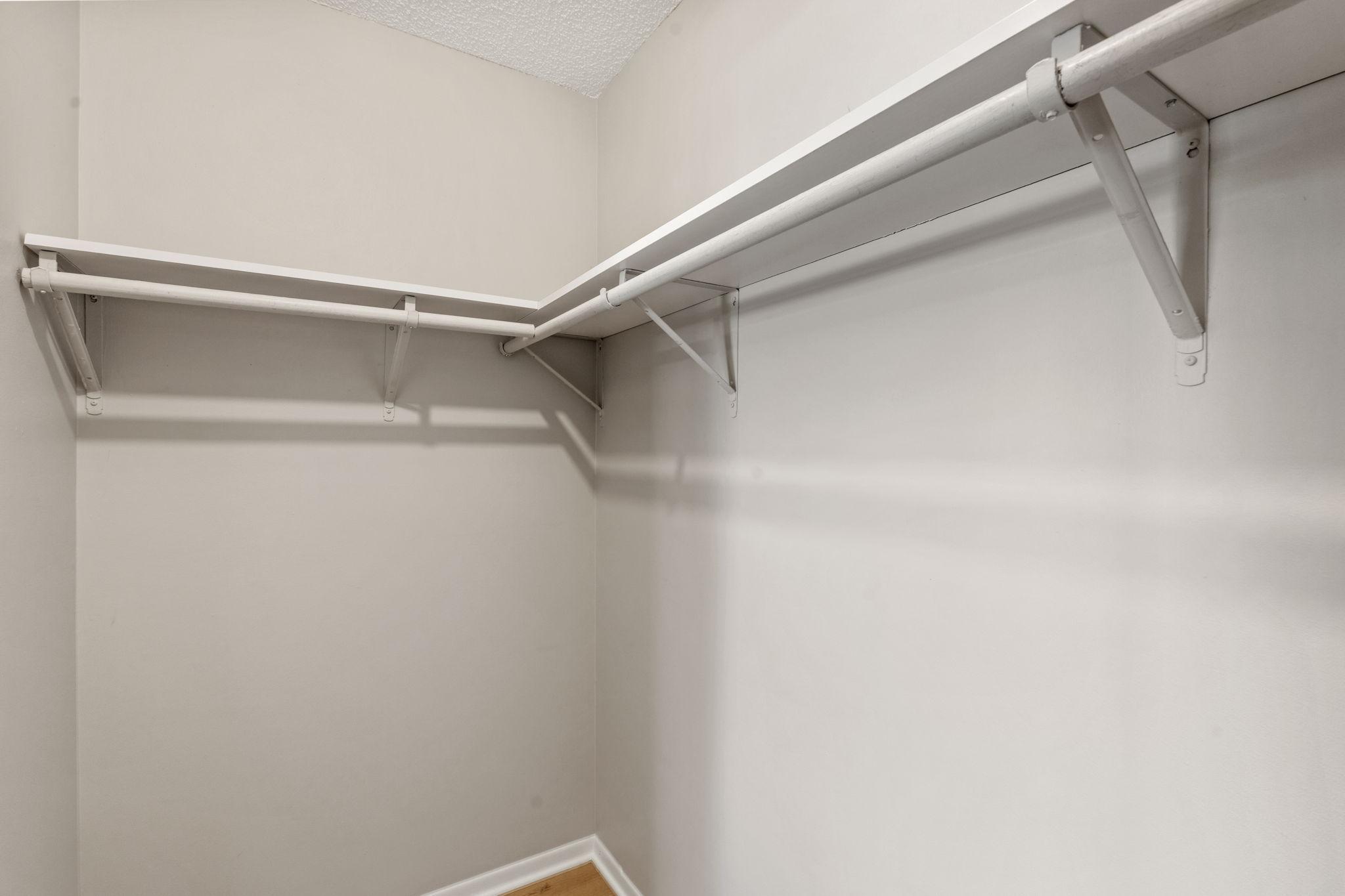 Walk-in closet with shelving and hanging space.