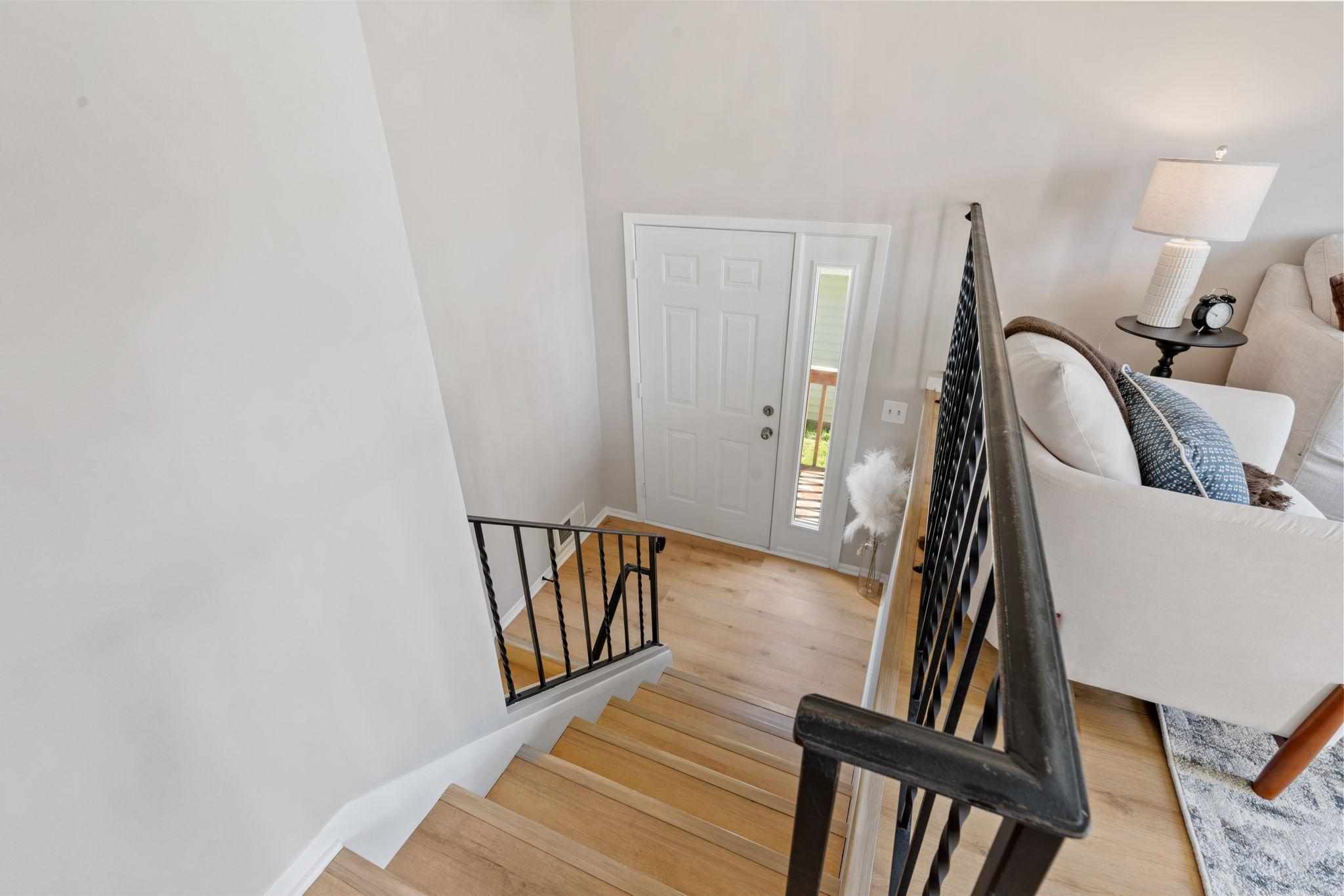 Welcoming entry with fresh paint, updated white oak flooring, and an open staircase.