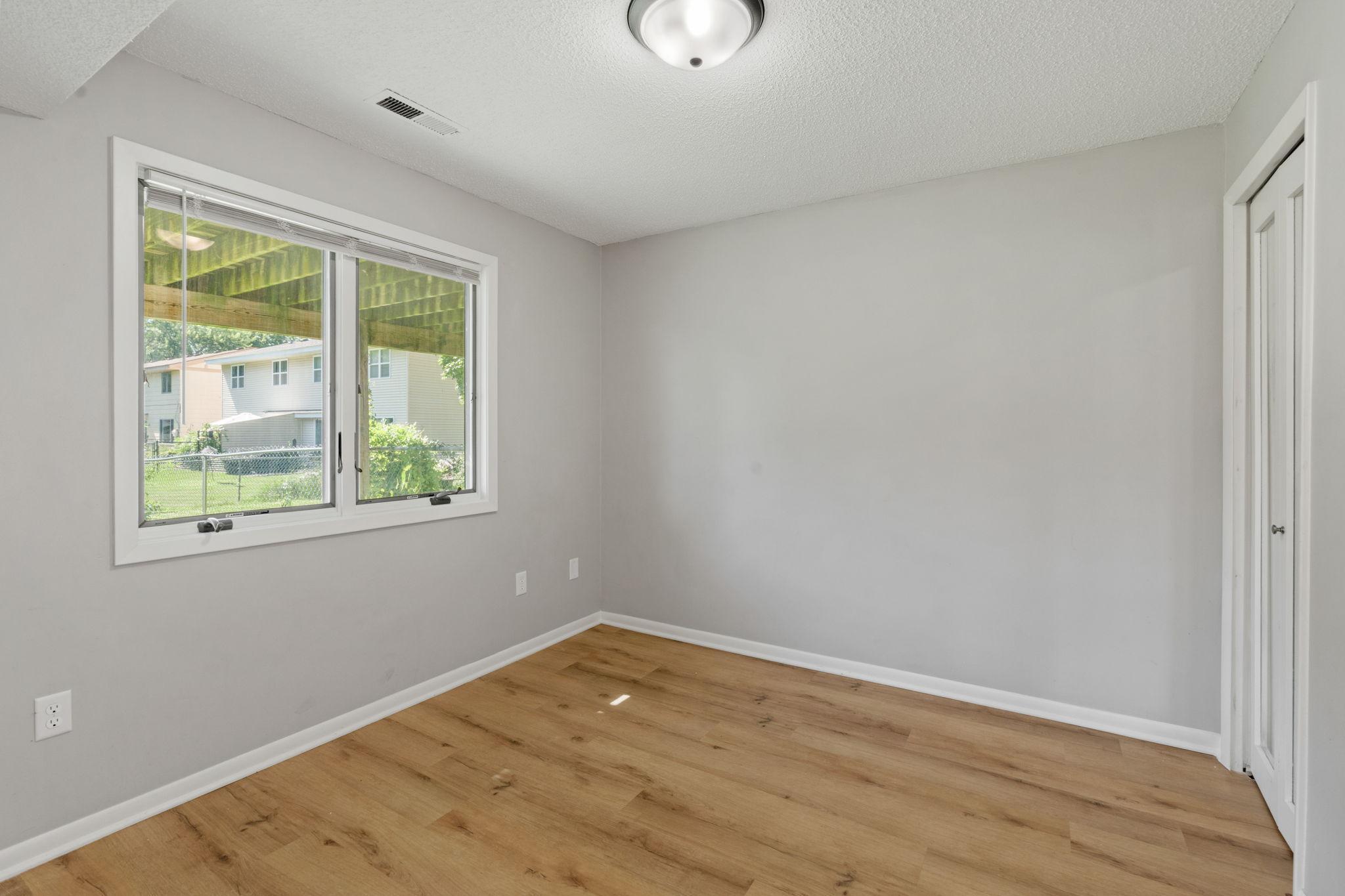 Secondary bedroom with updated flooring and large window.