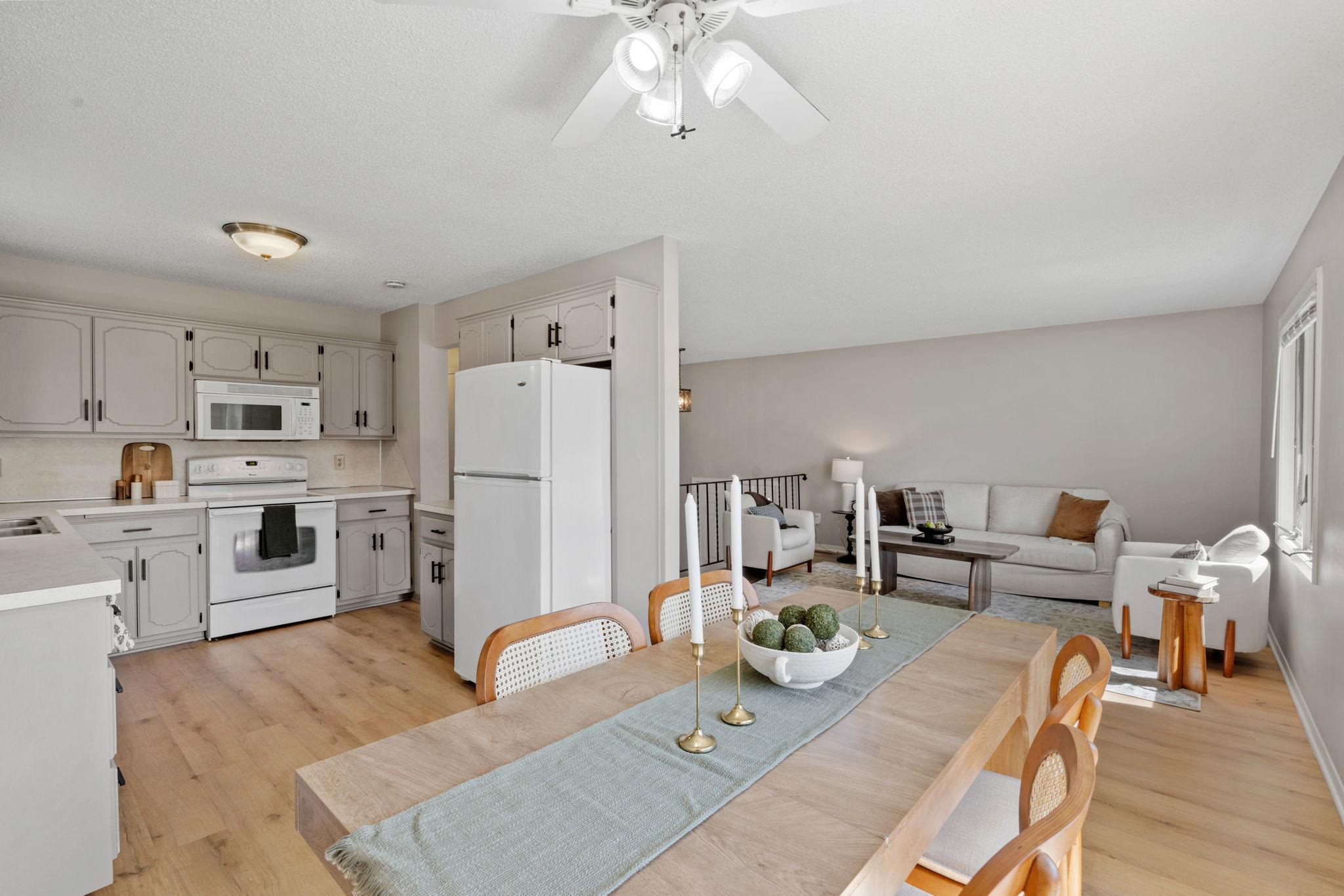 Open kitchen and dining area with updated flooring extending throughout the main level.