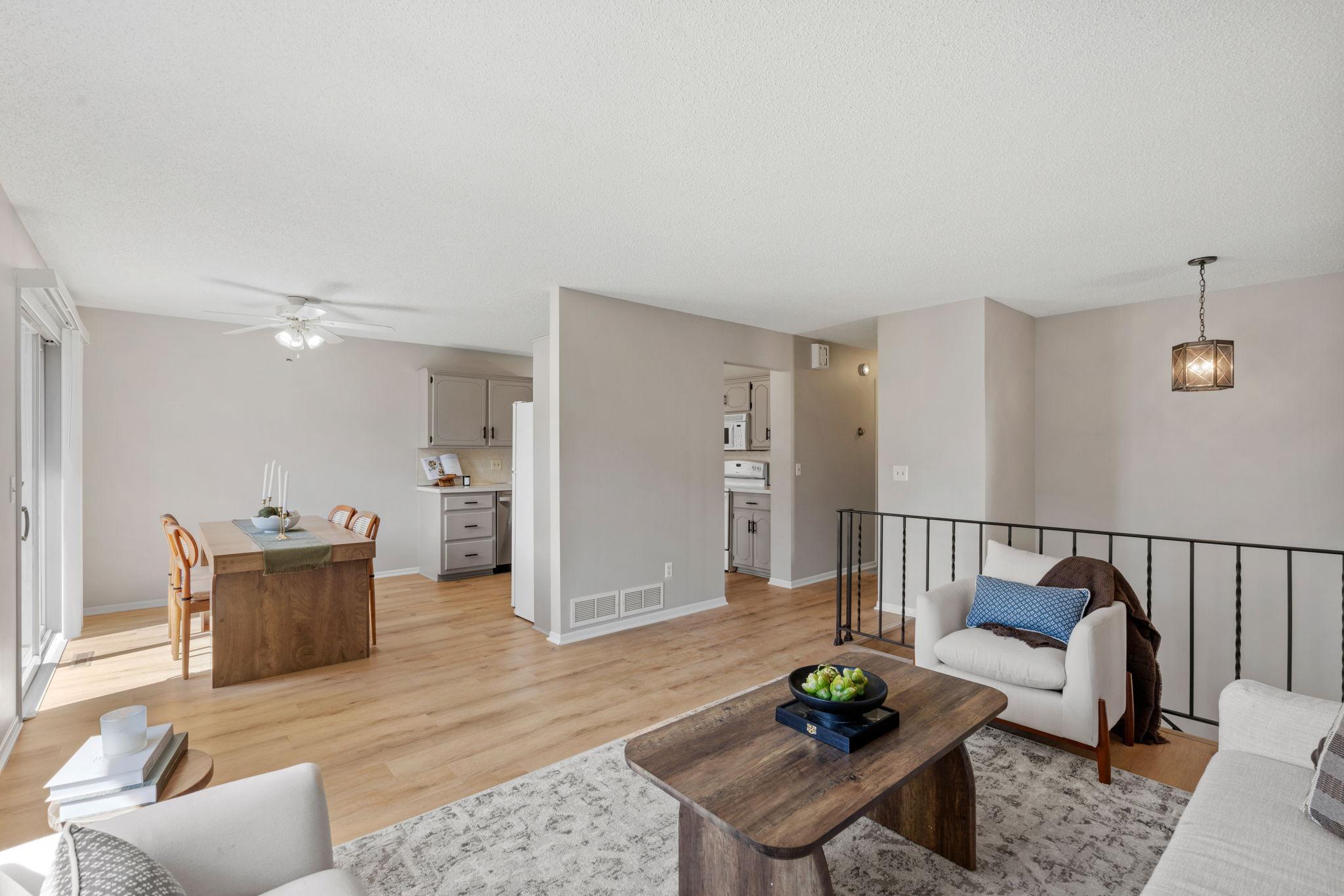 Main living area with updated white oak flooring connecting to the kitchen and dining space.