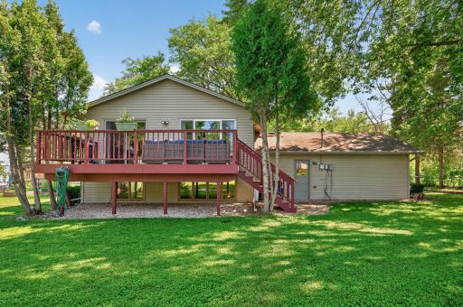 The rear exterior showcases the home's ample windows, attached garage, and large deck overlooking the backyard.