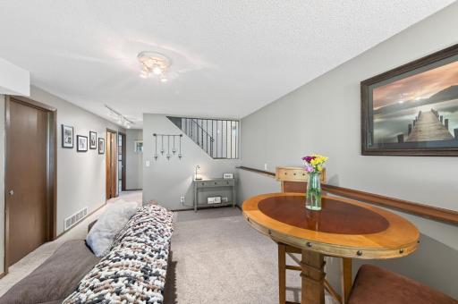 The open staircase to the entrance and foyer helps the lower level feel bright, open, and connected to the rest of the home.
