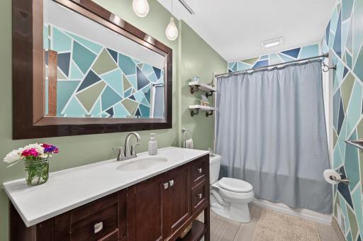 This stylish bathroom features a modern vanity, updated finishes, and a fun accent wall that adds personality to the space.