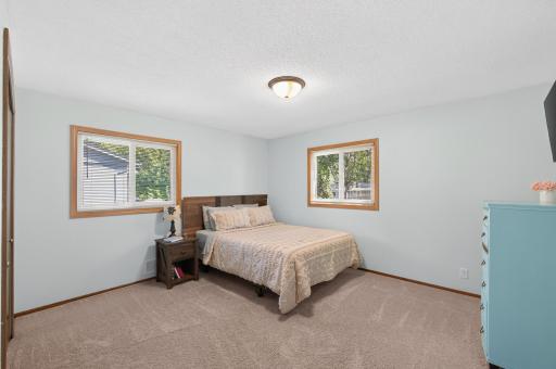 The spacious primary bedroom offers plenty of room for larger furniture, creating a comfortable retreat with abundant natural light.