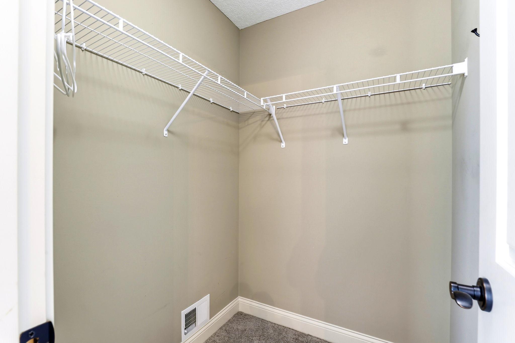 Walk-in closet complete with built-in wire shelving for optimal organization and storage.