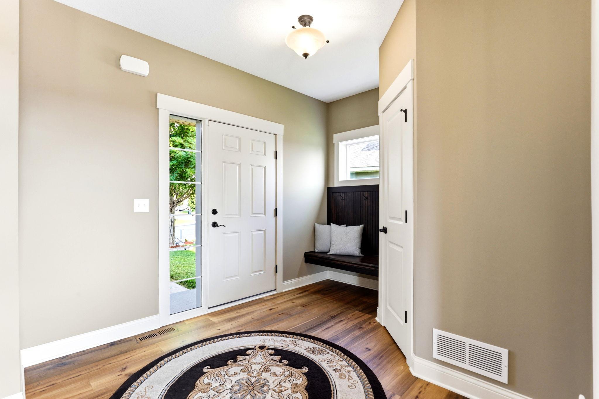 Welcoming entryway featuring new hardwood floors (2021), custom built-in bench, and Ring security video doorbell.