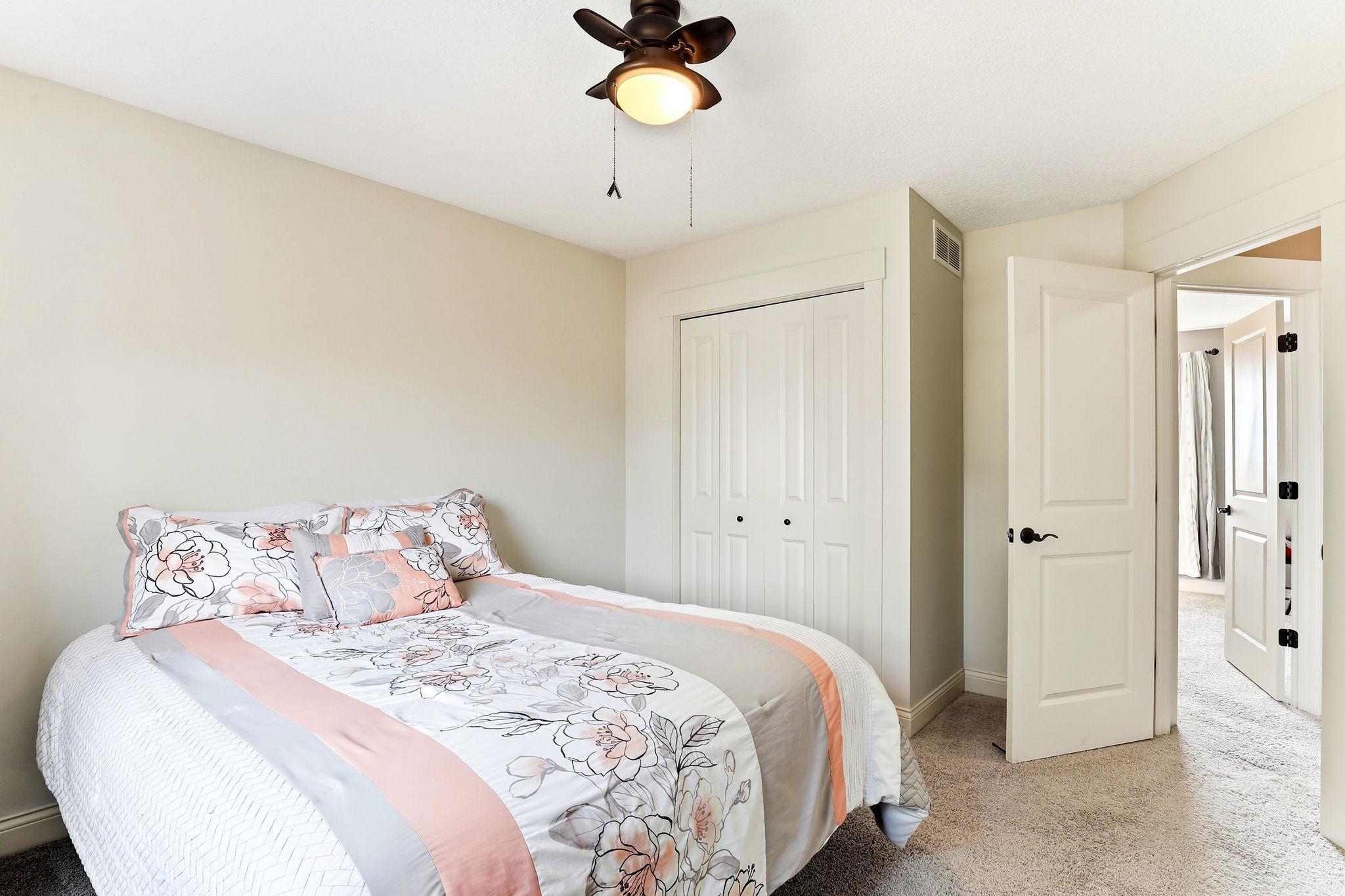 Third bedroom featuring double-door closet storage, plush carpeting, and flexible living options.