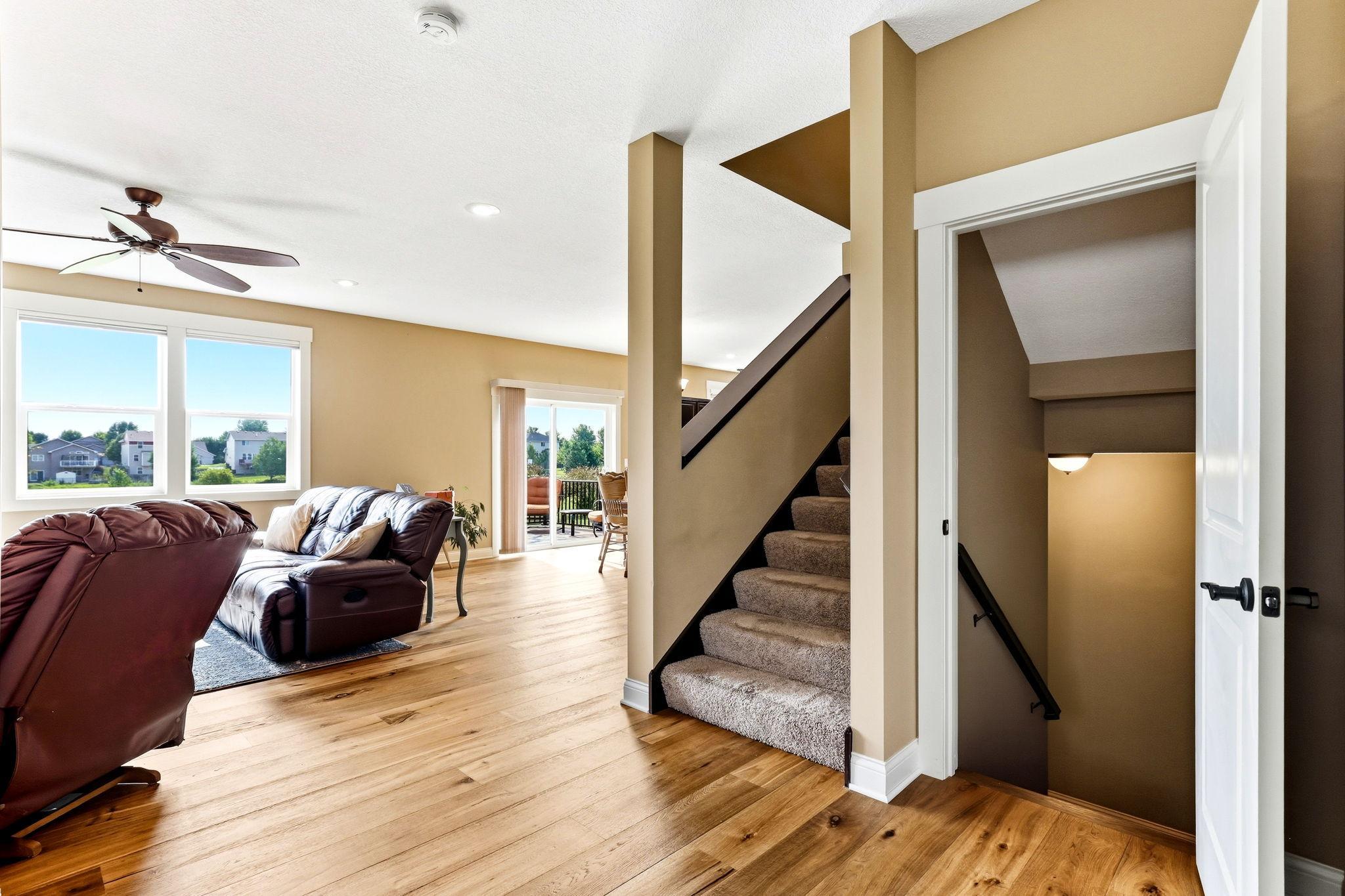 Main-level foyer showing the continuous hardwood flooring and entryway to the fully finished basement.