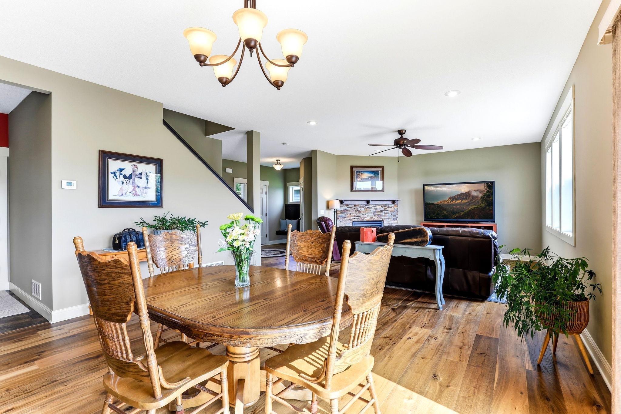 Bright dining area flowing directly into living space with continuous hardwood floors and natural light.
