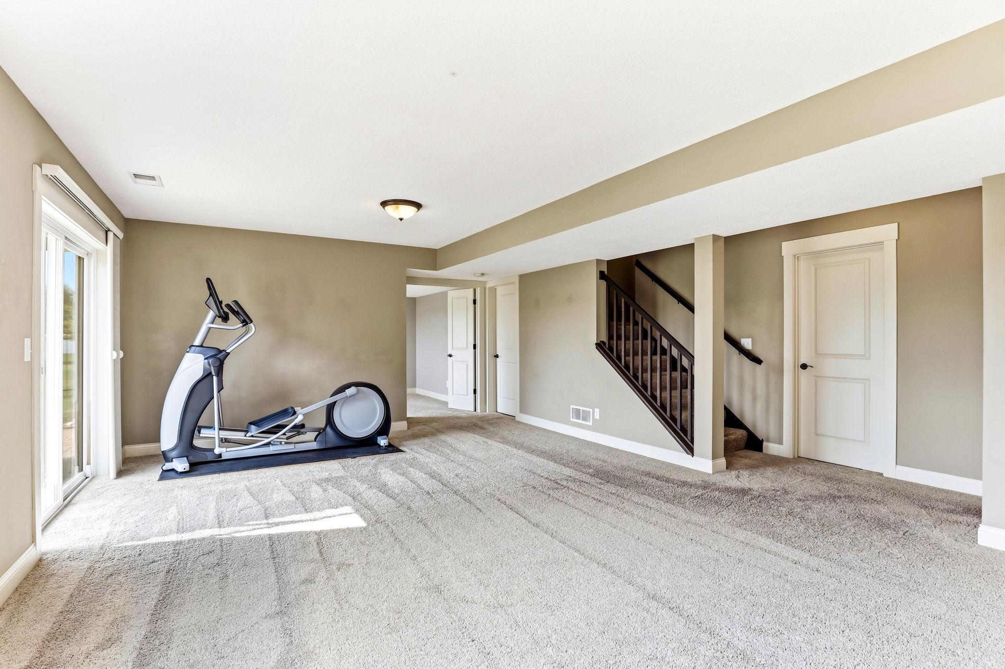 Open lower-level family room offers flexible space for media, fitness, recreation, and direct walkout access.