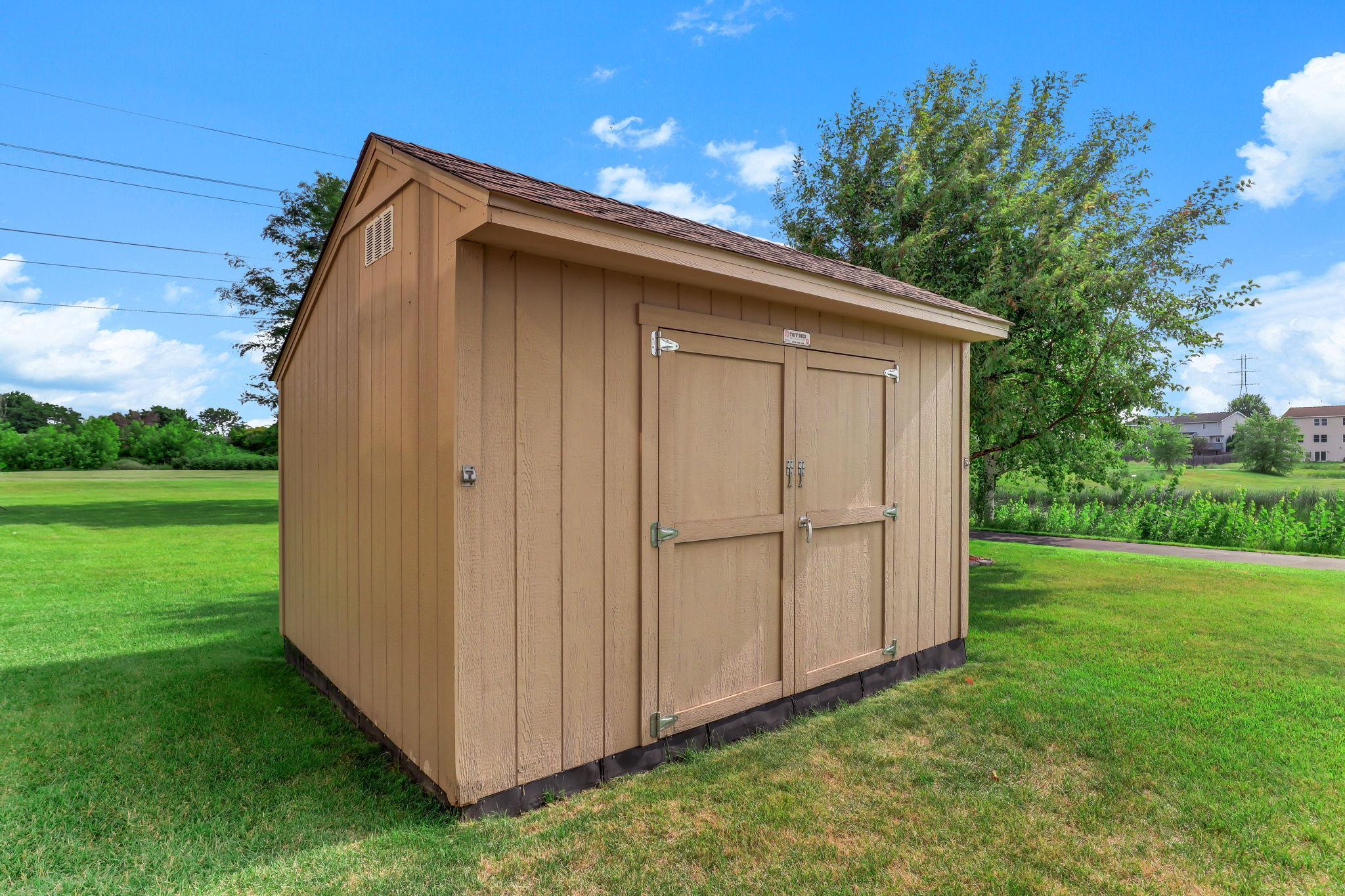 Sturdy 10’x12’ Tuff Shed providing additional outdoor storage for lawn care and recreational equipment.