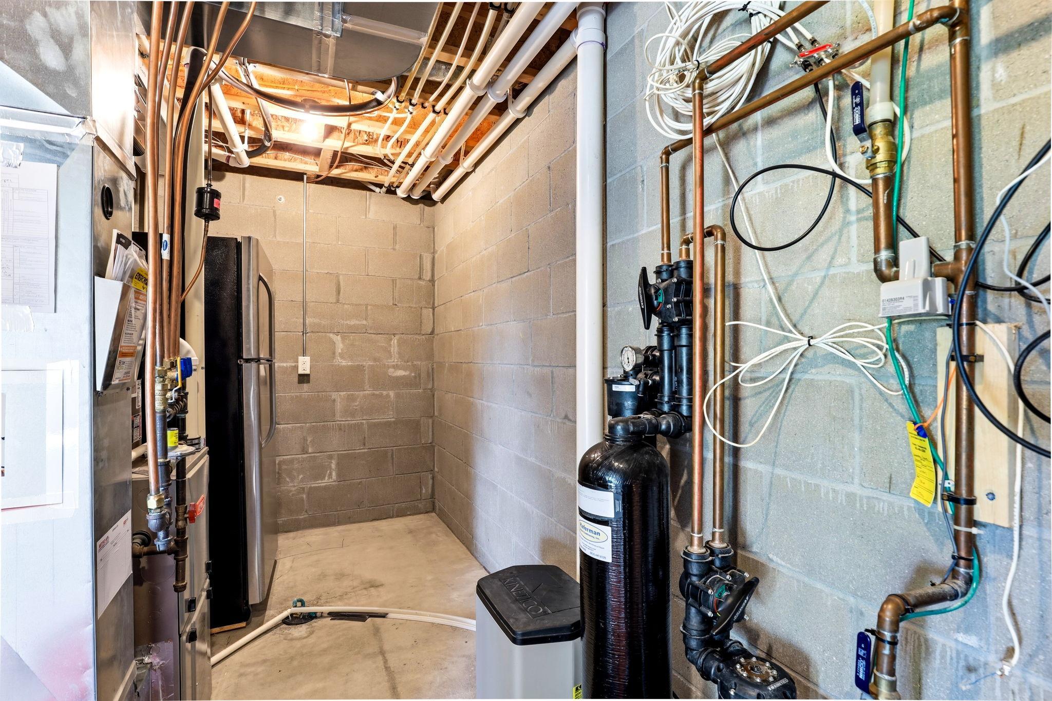 Mechanical room featuring Kinetico water softener system and newly installed tankless water heater (April 2025).