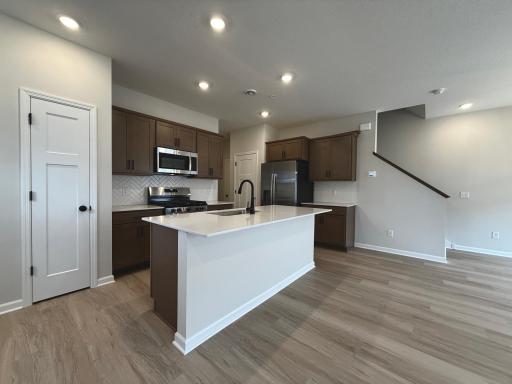 Large kitchen island provides ample working space with breakfast bar seating; perfect for busy mornings and hosting