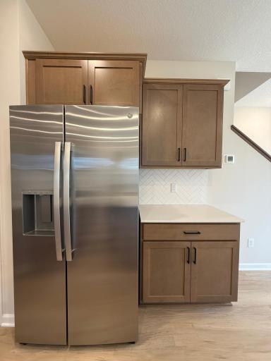 Side-by-side refrigerator keeps the kitchen space functional with an added coffee bar with tile backsplash