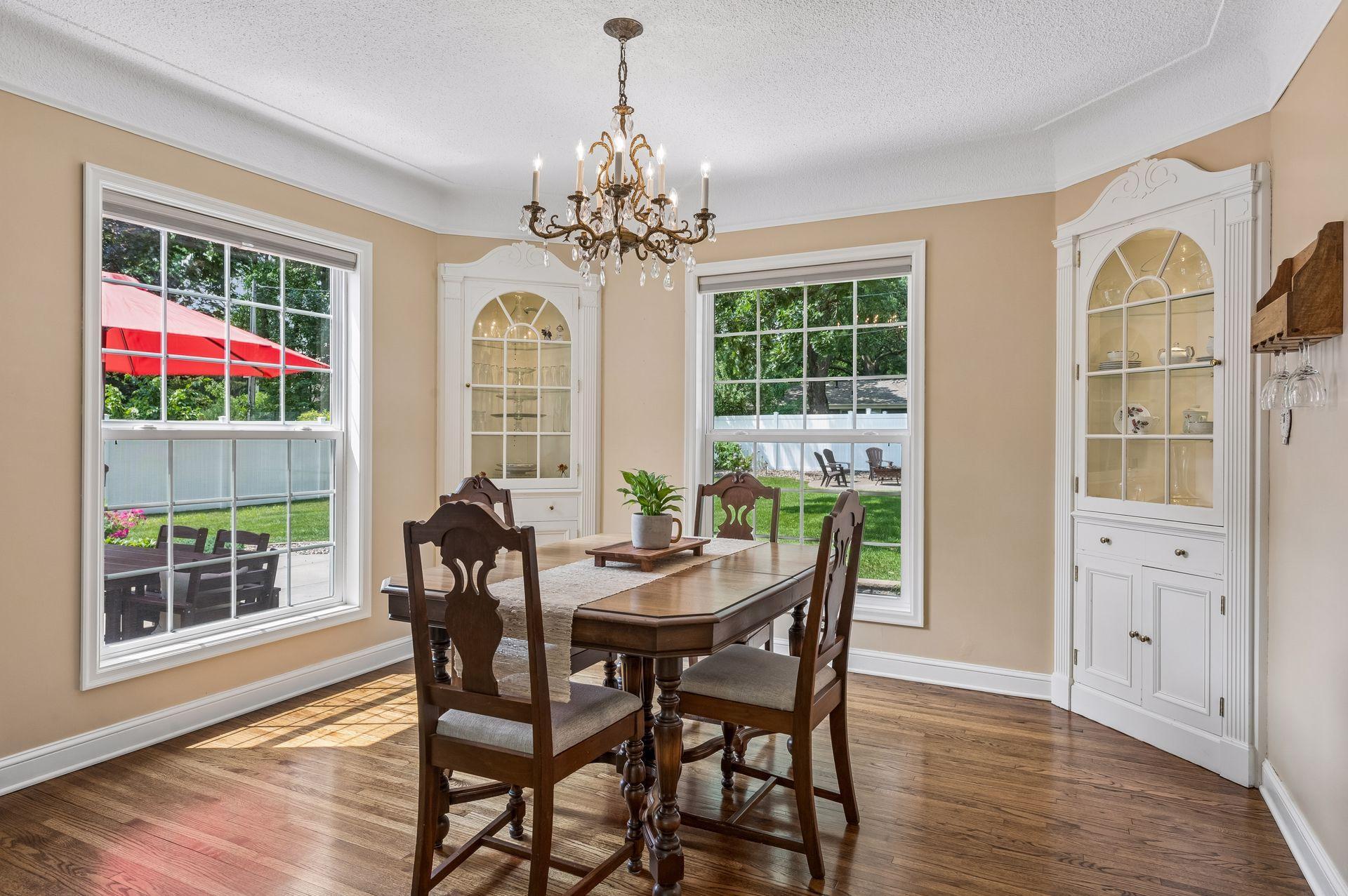 The separate formal dining room has more storage with original built-ins and chandelier, looking back into the very private and spacious backyard