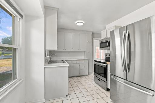 Kitchen. Painted cabinetry, stainless steel French door refrigerator, stainless range and over-the-range microwave, ceramic tile flooring.
