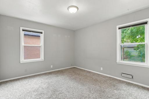 Bedroom. Carpet with two windows on adjacent walls.