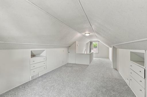 Upper level. Vaulted ceiling, carpet, and built-in drawer storage along both knee walls.