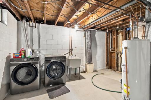 Laundry. Side by side washer and dryer, utility sink, and a water heater and water softener installed in 2025.