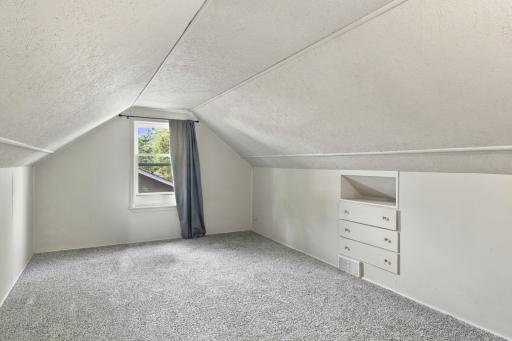 Upper level. Dormer window, sloped ceilings, carpet, and a built-in knee wall dresser.