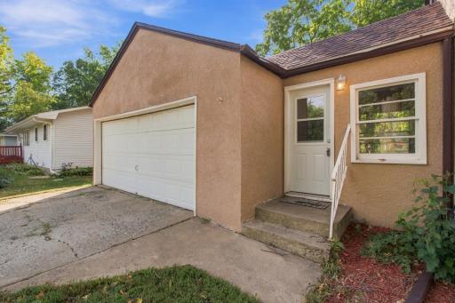 Garage. Two-car garage with overhead door, service door, and concrete driveway.