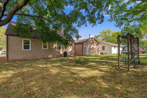 Rear yard. Open lawn with the house and garage beyond.