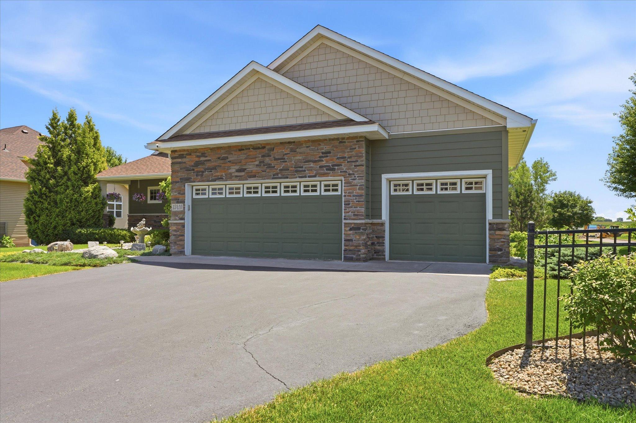 Spacious fully insulated and three-car garage offers in floor heat, ample room for vehicles, storage, and hobbies, complemented by a wide asphalt driveway for additional parking.