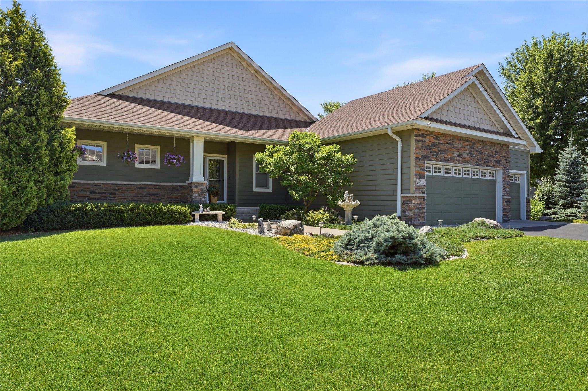 Beautiful curb appeal is enhanced by professional landscaping, a newer roof (2024), and gutters, creating an attractive and well-maintained exterior.