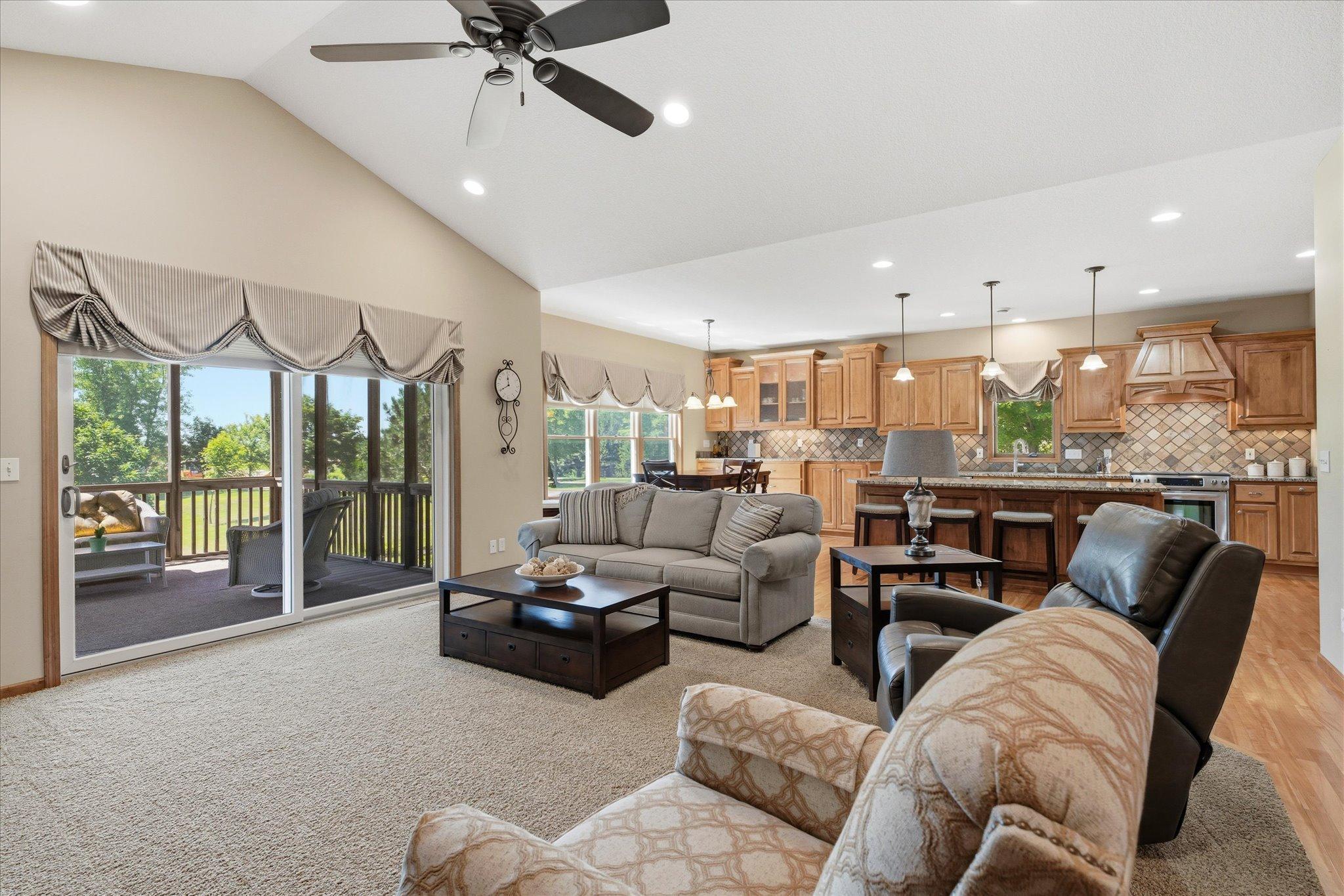 Expansive great room features soaring vaulted ceilings, recessed lighting, and an open-concept design that flows seamlessly into the kitchen and dining area, creating the perfect space for everyday living and entertaining.