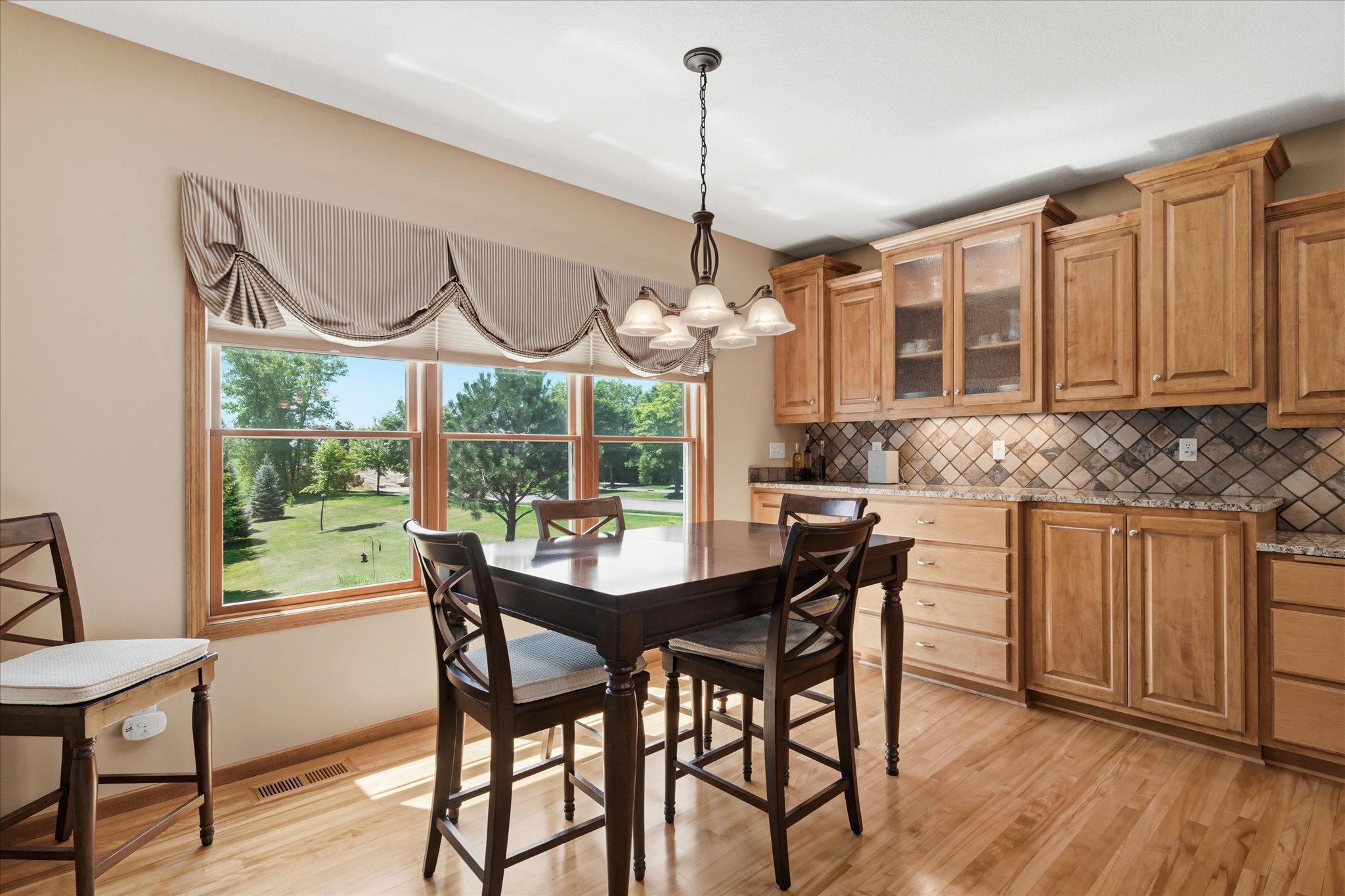 Sunny dining area is surrounded by large windows and features a beautiful built-in maple buffet with additional cabinetry, providing exceptional storage and serving space for entertaining.