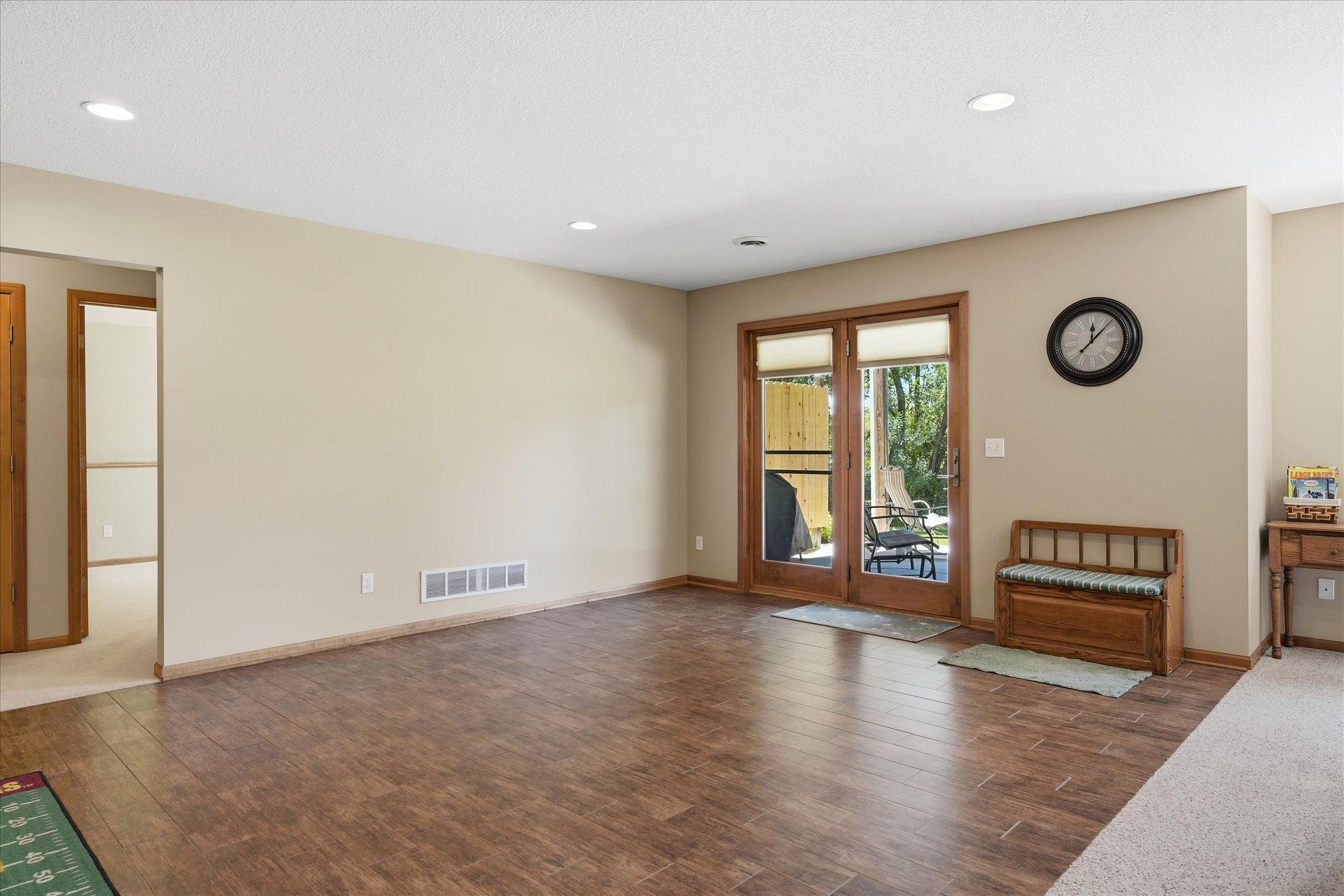 Expansive lower-level flex space offers endless possibilities with durable tile flooring, recessed lighting, and a convenient walkout to the backyard patio.