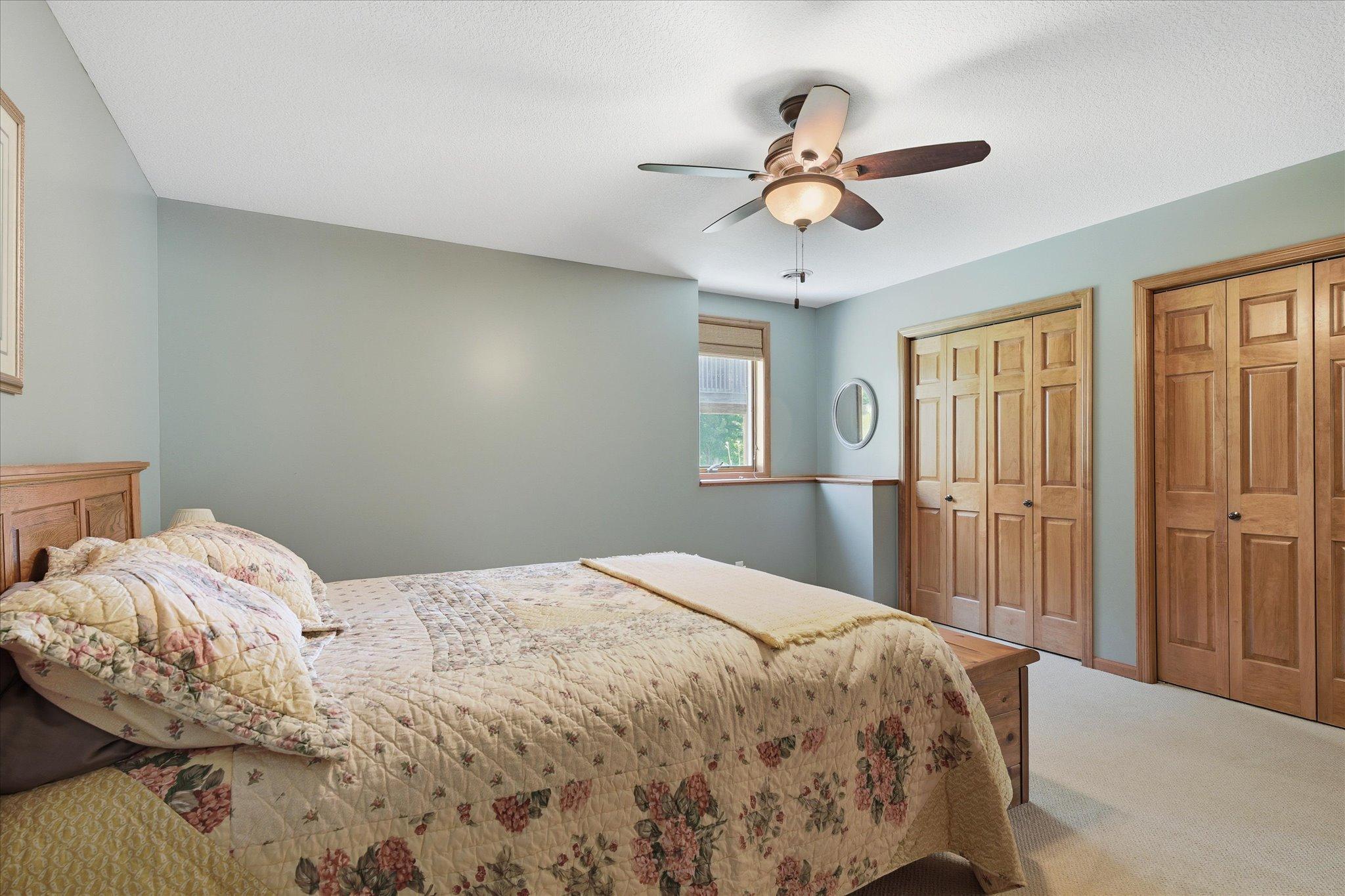 Lower-level bedroom #3 highlighting the dual closets, ceiling fan, and generous storage for everyday convenience.
