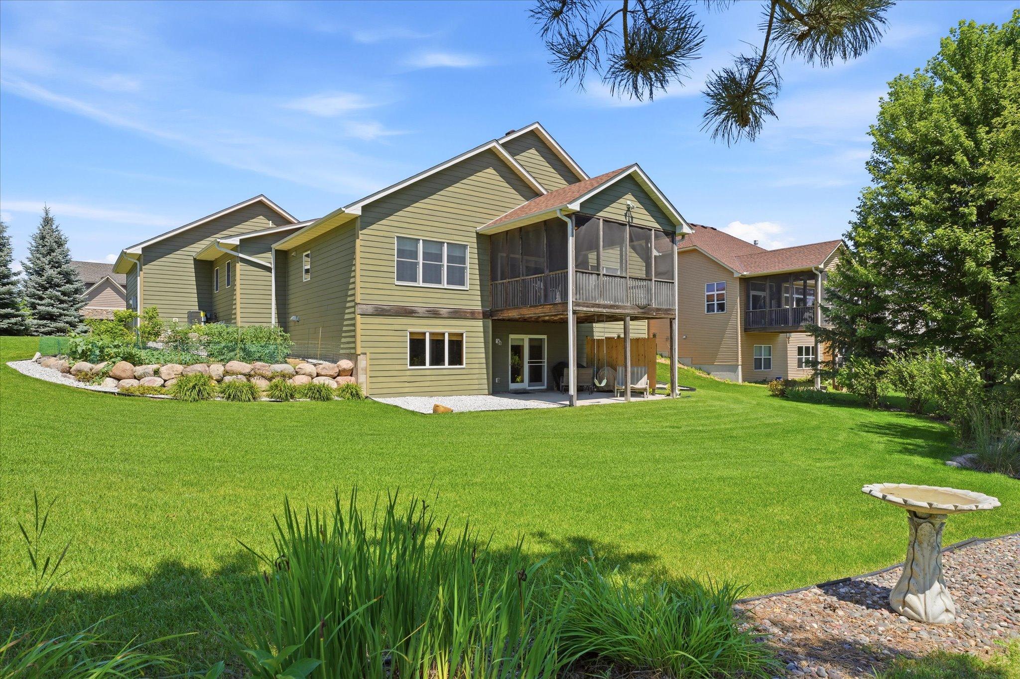 Expansive backyard backs to open green space with mature landscaping.