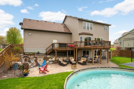 This is a backyard oasis, complete with a large deck and lower paver patio, above ground pool, and a sportcourt.