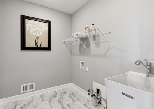 Photo is from when the home was staged as a model home. The Laundry shelve and washing basin / sink remain installed with the home.