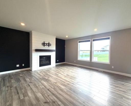 The main floor great room offers a ton of space for all to enjoy! There is a beautiful shiplap gas fireplace bringing the modern charm to the room & space on either side offering plenty of options for storage or decor. TV mount & blinds are included.