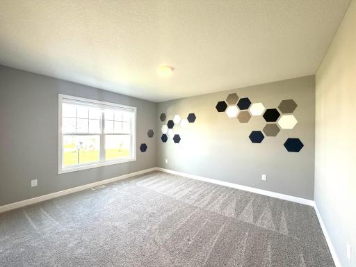 The 3rd bedroom on the upper level is large and offers a ton of light! The accent wall remains along with the window blinds. There is also a large walk in closet.