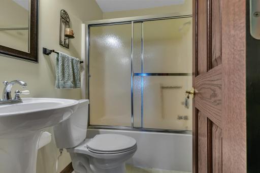 Main level full bath with glass door & pedestal sink. This home has many great features and is move-in ready. Come enjoy lake life at it's finest!