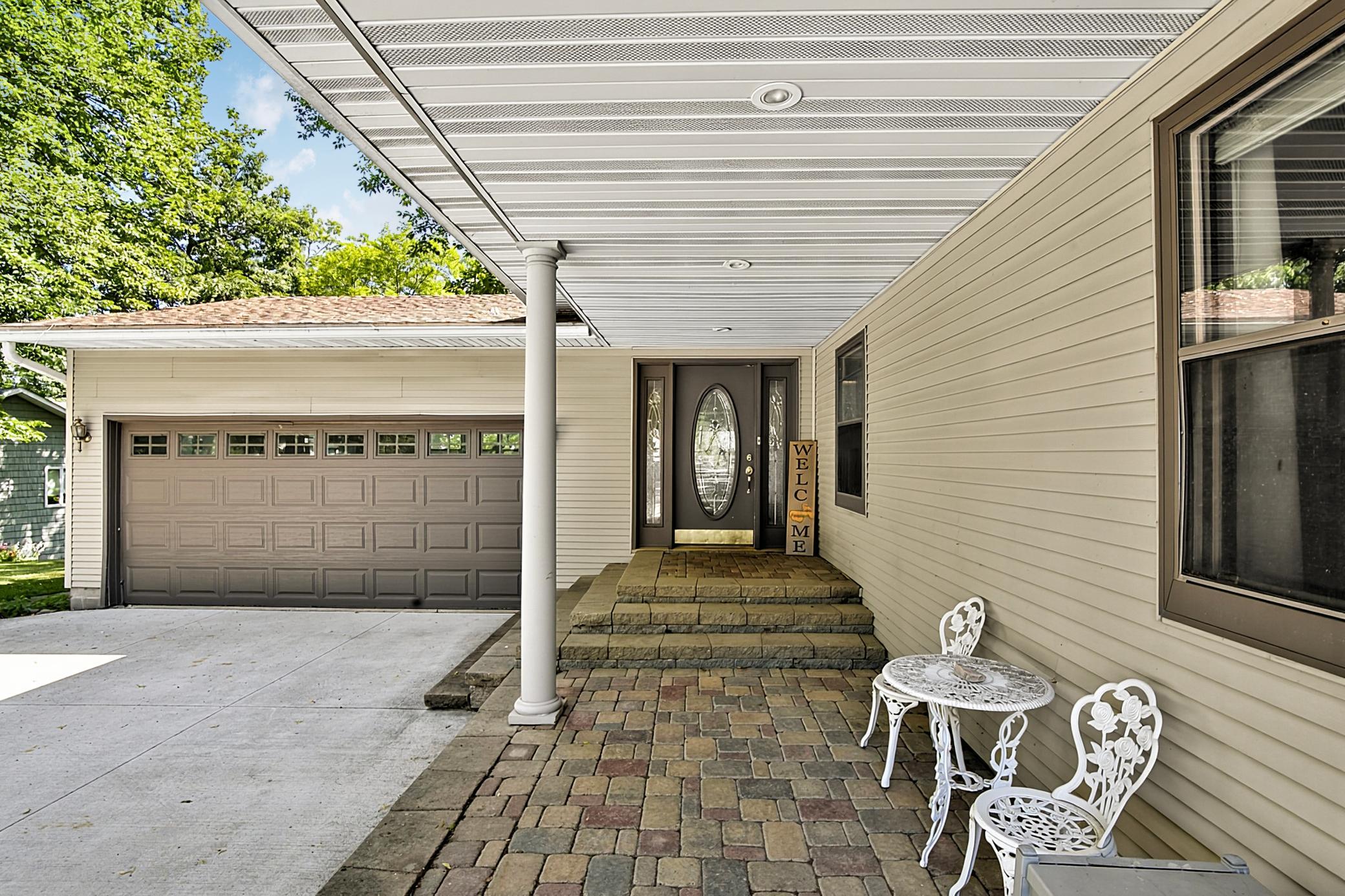 Welcoming covered entry is wonderful to sit and enjoy nature. This paver patio is a great addition to this already fantastic lake home. Oh, and the concrete driveway is next too new!