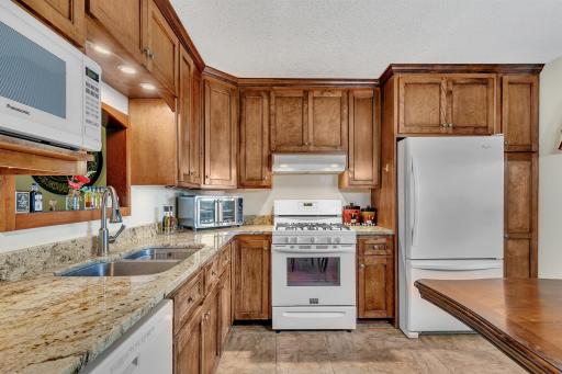 Another view of the kitchen, tile floors, and granite counter tops. This home is move-in ready for you to enjoy!
